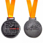 Medalha com relevo - Medalha com relevo frente e verso, sem cor, banho de prata velha, montada com fita de cetim laranja.